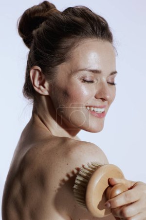 Foto de Feliz joven hembra con masajeador sobre fondo blanco. - Imagen libre de derechos