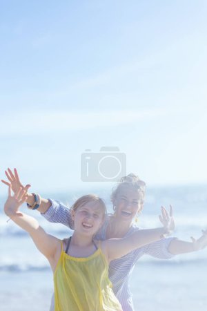 Foto de Sonriente elegante madre y el niño en la playa divertirse. - Imagen libre de derechos