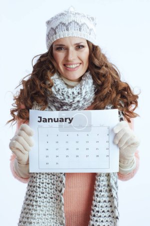 Photo for Hello winter. happy stylish woman in sweater, mittens, hat and scarf with january calendar isolated on white. - Royalty Free Image