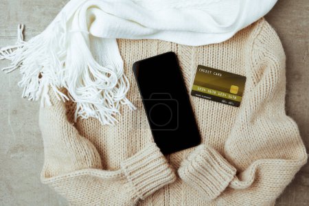Photo for Winter flat lay with scarf, smartphone, credit card and sweater. - Royalty Free Image