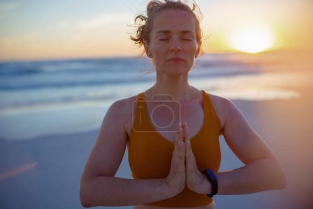 Téléchargez les photos : Relaxed healthy woman jogger in fitness clothes with fitness tracker meditating. - en image libre de droit