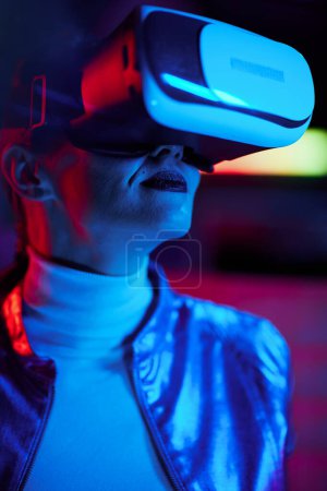 Téléchargez les photos : Neon metaverse futuristic concept. stylish business woman in virtual reality goggles on dark background. - en image libre de droit