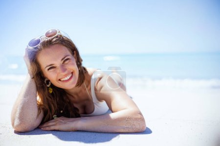 Foto de Portrait of happy elegant female laying at the beach. - Imagen libre de derechos