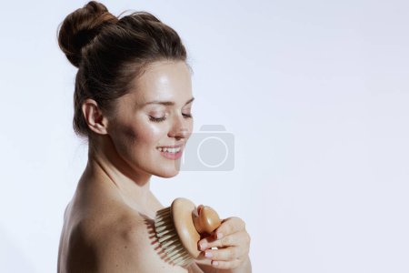 Foto de Smiling young woman with massager isolated on white background. - Imagen libre de derechos
