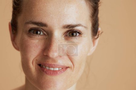 Téléchargez les photos : Smiling modern woman with wet face washing isolated on beige. - en image libre de droit