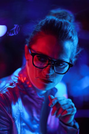 Foto de Neon metaverse futuristic concept. concerned modern business woman in glasses. - Imagen libre de derechos