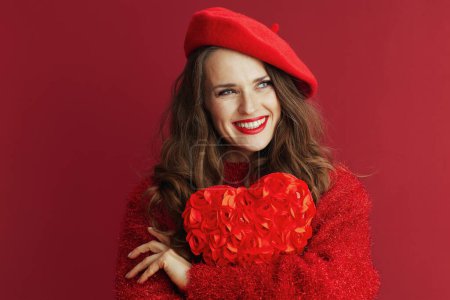 Téléchargez les photos : Happy Valentine. smiling modern female in red sweater and beret with red heart hugging red heart. - en image libre de droit