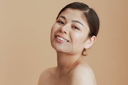 Téléchargez les photos : Portrait of modern asian female looking in camera against beige background. - en image libre de droit