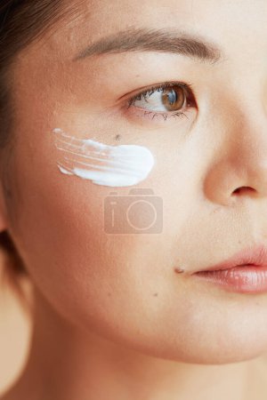 Foto de Closeup on woman with facial cream on face. - Imagen libre de derechos