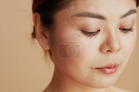 Téléchargez les photos : Modern woman looking down against beige background. - en image libre de droit