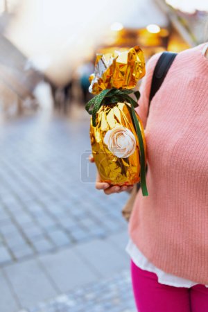 Foto de Easter fun. Closeup on woman with golden easter egg at the fair in the city. - Imagen libre de derechos