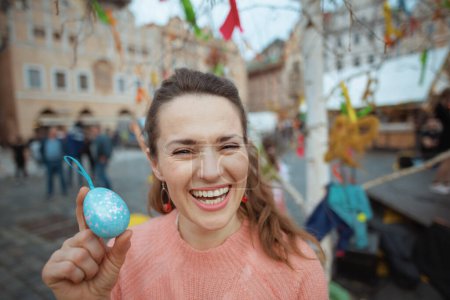 Photo for Easter fun. young female in pink blouse with easter egg at the fair in the city. - Royalty Free Image