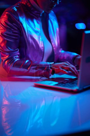 Foto de Neon metaverse futuristic concept. Closeup on woman with laptop in office. - Imagen libre de derechos