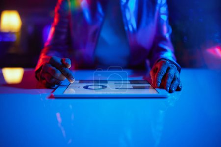 Téléchargez les photos : Neon metaverse futuristic concept. Closeup on woman with tablet PC exploring graphs. - en image libre de droit