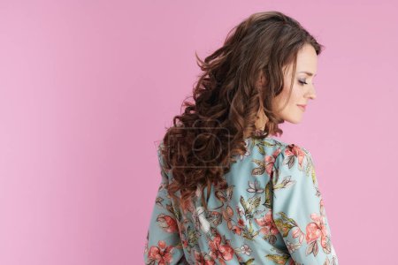 Foto de Relaxed trendy 40 years old woman in floral dress isolated on pink. - Imagen libre de derechos