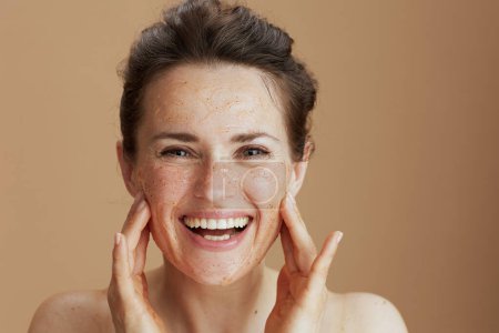 Photo for Portrait of smiling modern woman with face scrub on beige background. - Royalty Free Image