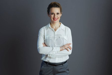 Photo for Happy trendy female worker in white blouse against grey background. - Royalty Free Image