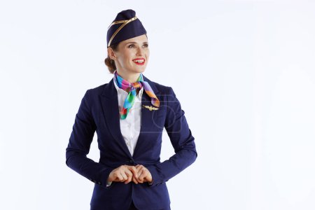 glücklich elegante Flugbegleiterin isoliert auf weißem Hintergrund in Uniform Blick auf Kopierraum.