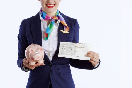 Photo for Closeup on stylish flight attendant woman against white background in uniform with flight tickets and piggy bank. - Royalty Free Image