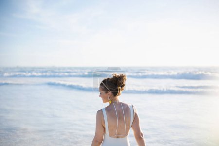 Téléchargez les photos : Happy elegant female in white beachwear at the beach relaxing. - en image libre de droit