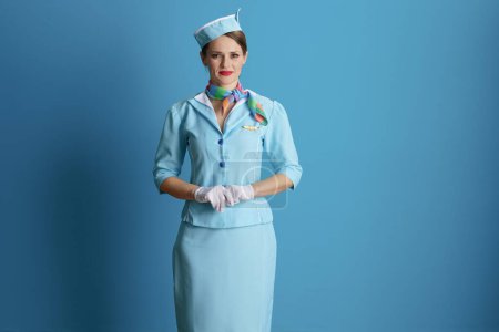 Photo for Stylish stewardess woman against blue background in blue uniform. - Royalty Free Image