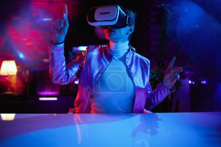 Photo for Neon metaverse futuristic concept. modern woman in vr headset in modern office create project in virtual reality. - Royalty Free Image