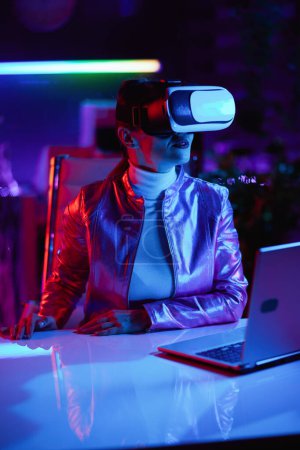 Photo for Neon metaverse futuristic concept. trendy business woman in virtual reality goggles in modern office. - Royalty Free Image
