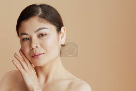 Téléchargez les photos : Portrait de jeune femme asiatique sur fond beige. - en image libre de droit