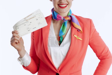 Téléchargez les photos : Gros plan sur heureuse hôtesse de l'air élégante femme sur fond blanc en uniforme avec billets d'avion. - en image libre de droit