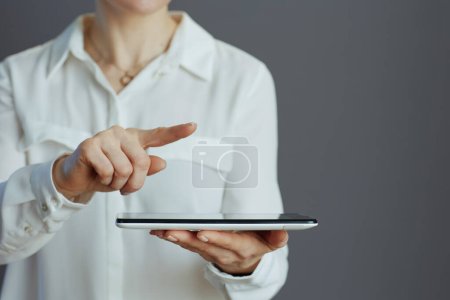 Foto de Primer plano de la trabajadora en blusa blanca con tableta PC sobre fondo gris. - Imagen libre de derechos