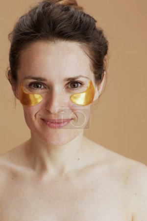 Photo for Happy modern woman with eye patches isolated on beige background. - Royalty Free Image