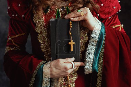 Photo for Closeup on medieval queen in red dress with book and rosary. - Royalty Free Image