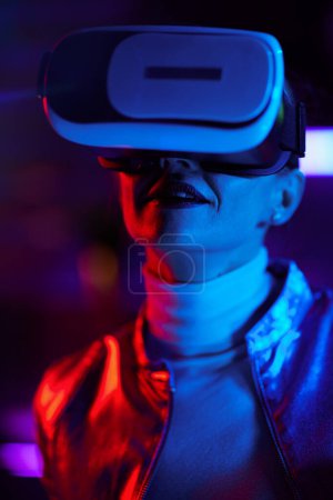Téléchargez les photos : Neon metaverse concept futuriste. élégante femme d'affaires en vr casque sur fond sombre. - en image libre de droit
