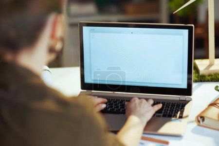 Foto de Primer plano de la mujer de negocios moderna con el ordenador portátil escribir correo electrónico en la oficina moderna. - Imagen libre de derechos