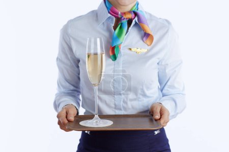 Photo for Closeup on elegant female flight attendant isolated on white background in uniform with a glass of champagne. - Royalty Free Image