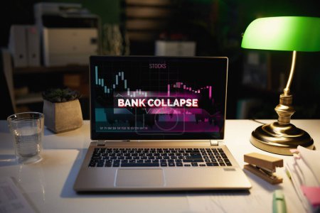 Photo for Desk with laptop with bank collapse screen at night in the modern office. - Royalty Free Image