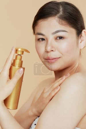 Téléchargez les photos : Femme moderne avec crème contour sur fond beige. - en image libre de droit