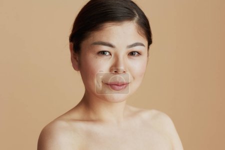Téléchargez les photos : Portrait de femme asiatique moderne regardant à la caméra isolé sur fond beige. - en image libre de droit