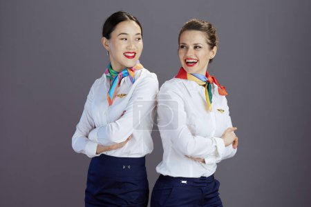 Photo for Happy elegant stewardess women in blue skirt, white shirt and scarf isolated on gray. - Royalty Free Image