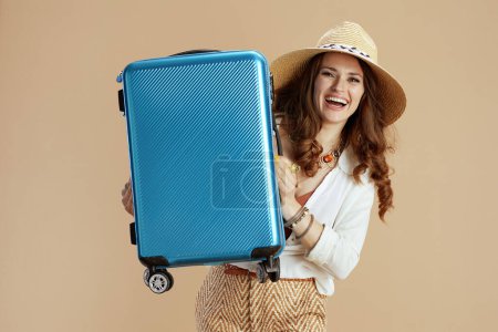Foto de Vacaciones en playa. mujer con estilo feliz en blusa blanca y pantalones cortos aislados en fondo beige con sombrero de paja y bolsa de carrito. - Imagen libre de derechos