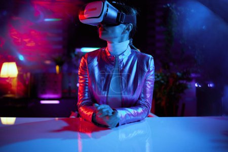 Photo for Neon metaverse futuristic concept. modern 40 years old woman in vr headset in modern office. - Royalty Free Image