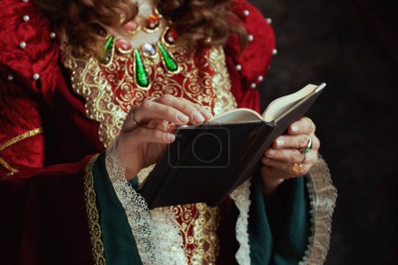 Photo for Closeup on medieval queen in red dress with book. - Royalty Free Image