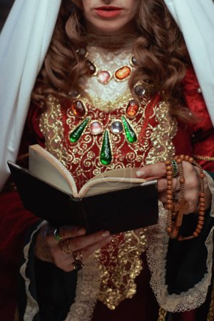 Téléchargez les photos : Gros plan sur la reine médiévale en robe rouge avec livre et voile. - en image libre de droit