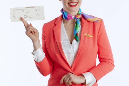 Foto de Primer plano en la sonrisa elegante azafata femenina sobre fondo blanco en uniforme con billetes de avión. - Imagen libre de derechos