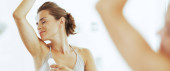 Woman enjoying freshness after applying roller deodorant on underarm t-shirt #652930744