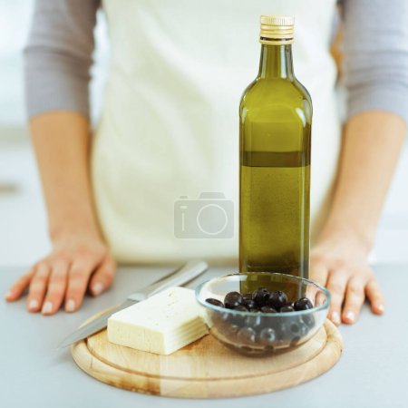 Foto de Primer plano sobre el queso, aceitunas y aceite de oliva en la tabla de cortar - Imagen libre de derechos