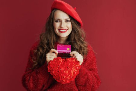 Photo for Happy Valentine. happy elegant woman in red sweater and beret with red heart and credit card. - Royalty Free Image