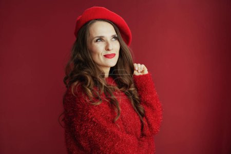 Foto de Feliz San Valentín. hembra pensativa de moda con pelo largo ondulado en suéter rojo y boina. - Imagen libre de derechos
