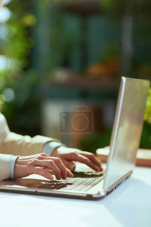 Foto de Primer plano de la mujer contable en la oficina verde con el ordenador portátil. - Imagen libre de derechos