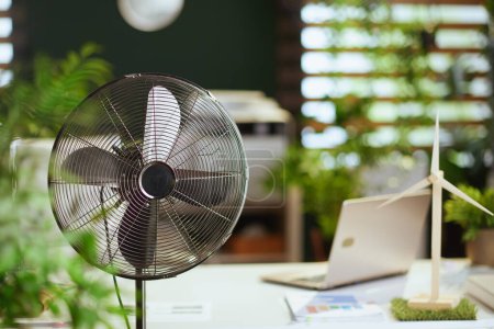 Téléchargez les photos : L'heure d'été. ventilateur métallique dans le bureau vert moderne. - en image libre de droit